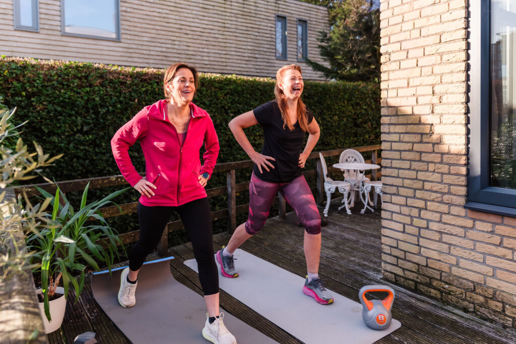 Deb guiding an exercise routine alongside a client, showing her active and practical coaching method.