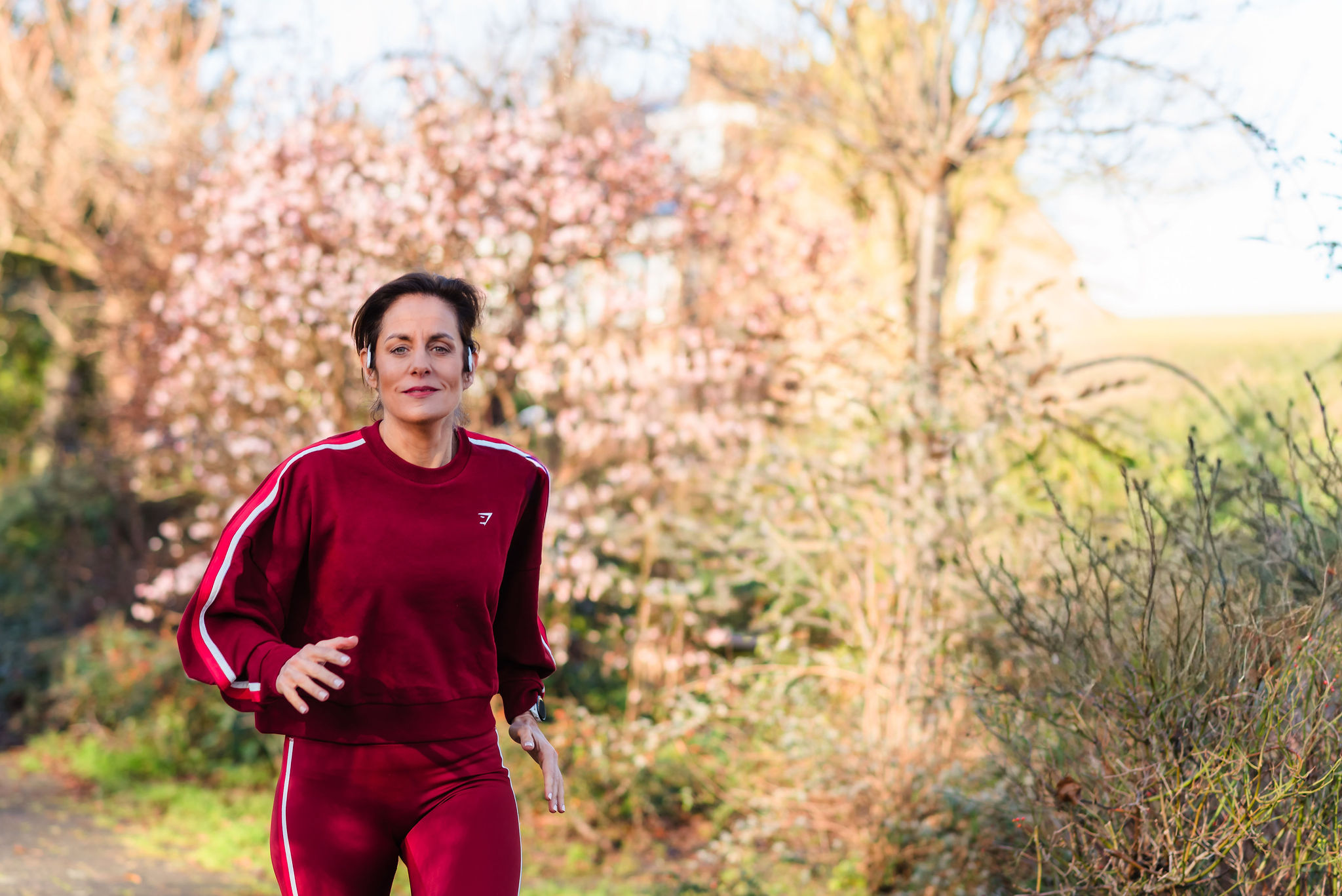 Deb running outdoors, representing the athletic coaching and active lifestyle of the program.
