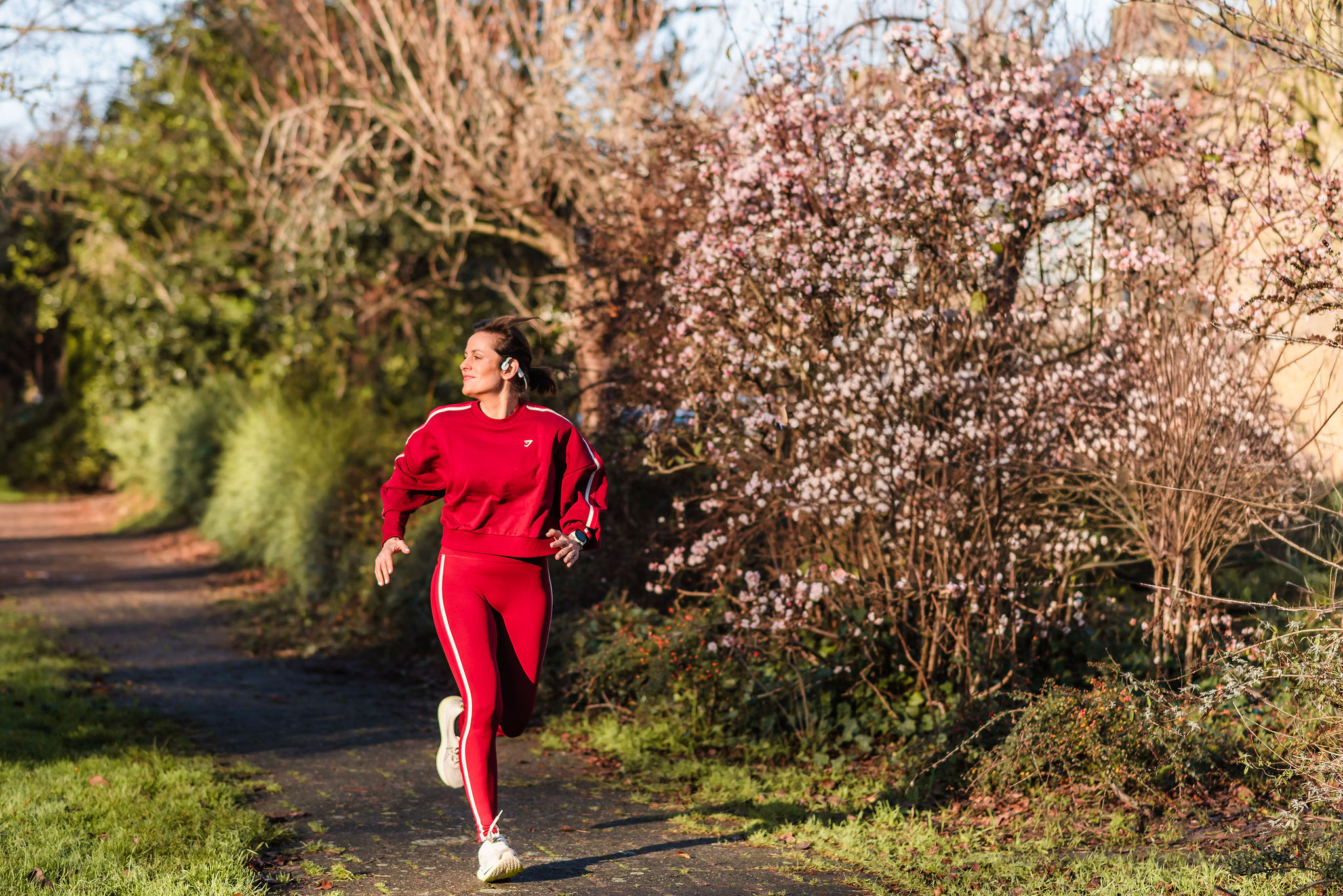 Deb running happily along a path in a blooming park, conveying the vitality and fulfillment achieved through the DEBs WAY program.
