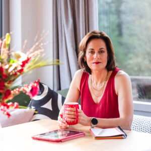 Portrait of Deb at her desk looking forward with a professional and welcoming attitude, marking the beginning of her personal story.
